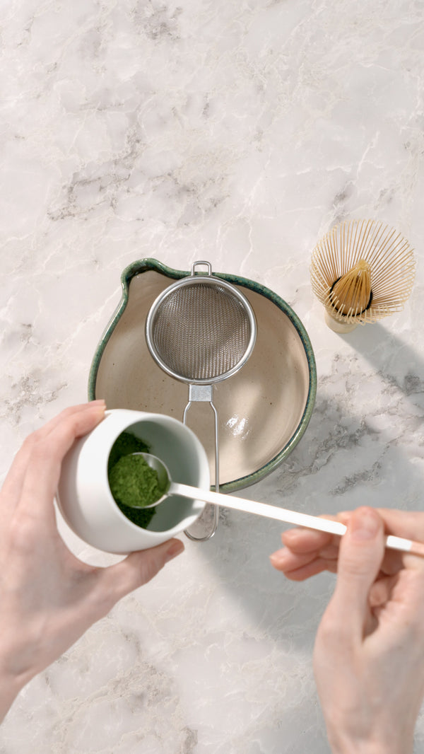 Scooping MUKU matcha with a spoon