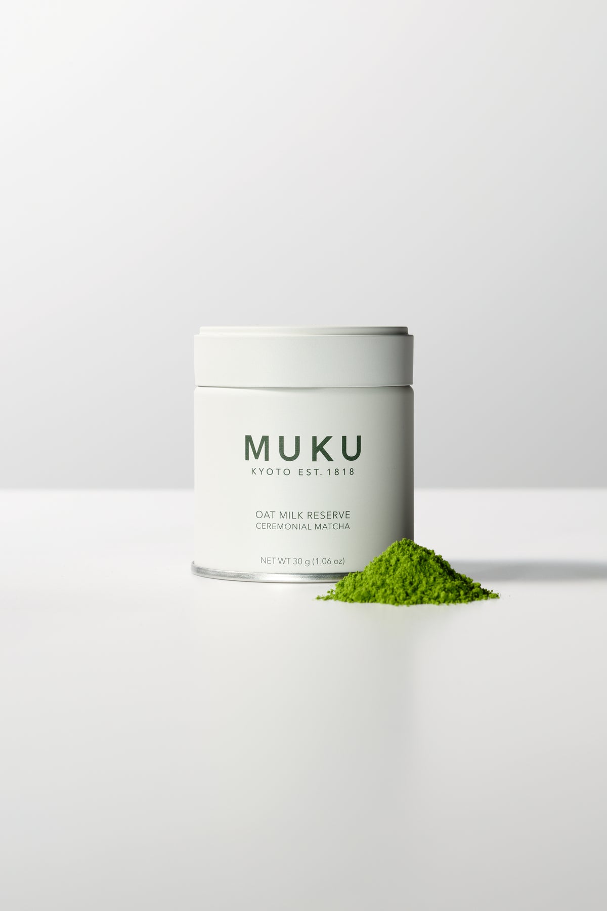 MUKU Oat Milk Reserve 30g tin, front view with matcha powder